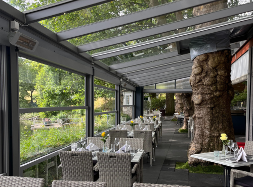 Guillotineglassystem als Zusatzelement einer Terrassenüberdachung in einem Restaurant